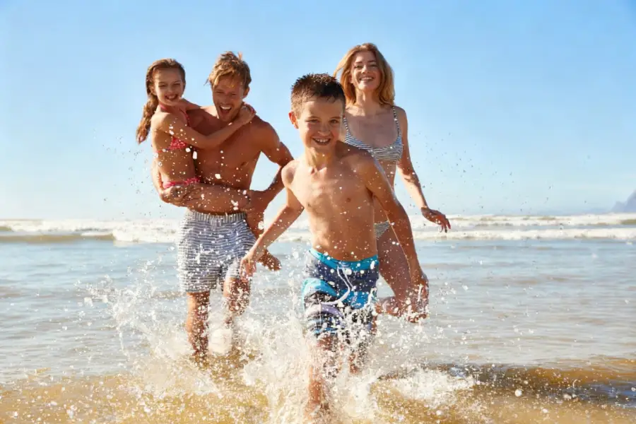 A family wearing swimsuits playing on the beach
