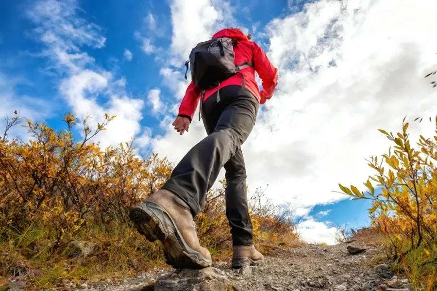 Woman in outdoor apparel Hiking Rocky Trail