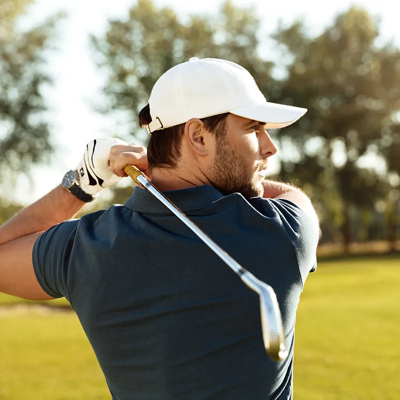 a young in golf wear concentrated man shooting golf ball