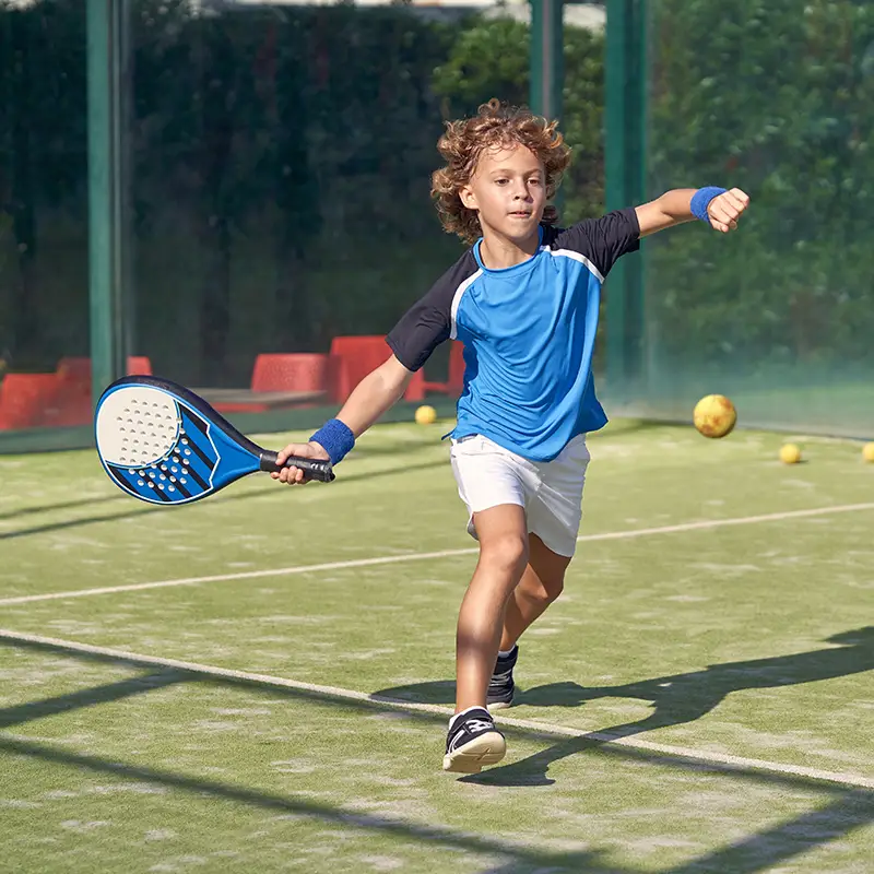 active boy in activewear hitting ball with racket