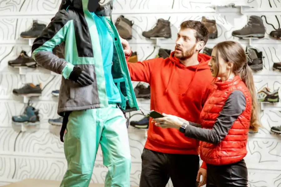 couple in red sports clothes choosing ski wear
