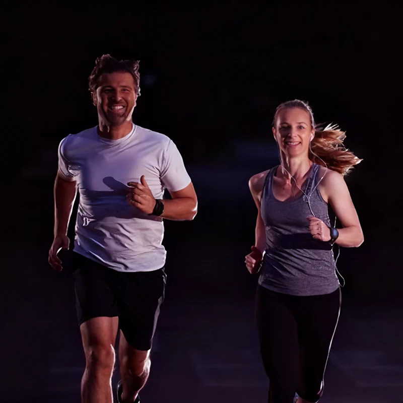 healthy couple jogging in running wear at night