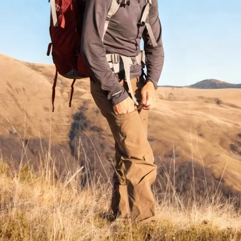 male hiker adjusting pocket zipper on trekking pants
